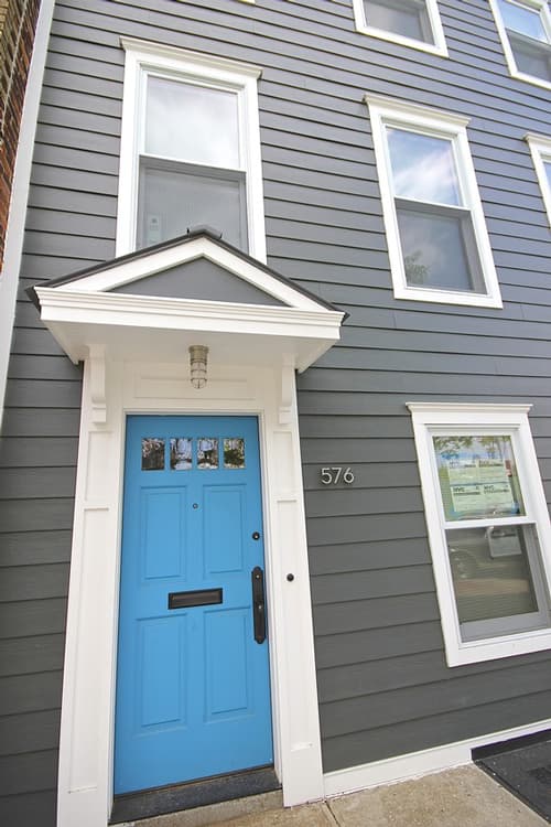 gray house with white trim and blue door