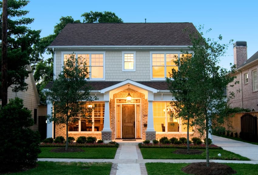 new-house-lighting House with beige shingle siding featuring a stylish pendant light above the front door.